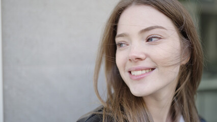 Wall Mural - Young blonde woman smiling confident looking to the side at street