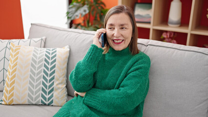 Sticker - Mature hispanic woman with grey hair talking on smartphone at home