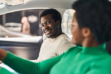 Poster - African american man and woman couple driving car at street