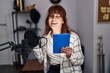 © Krakenimages.com - Middle age woman musician singing song holding touchpad at music studio