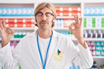 Sticker - Caucasian man with mustache working at pharmacy drugstore relax and smiling with eyes closed doing meditation gesture with fingers. yoga concept.