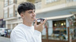 © Krakenimages.com - Young hispanic man sending voice message with smartphone at coffee shop terrace