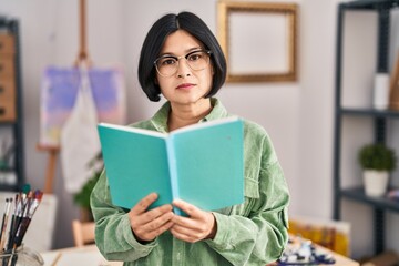 Wall Mural - Young chinese woman artist reading book at art studio