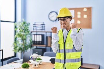 Wall Mural - Hispanic man wearing architect hardhat celebrating surprised and amazed for success with arms raised and eyes closed