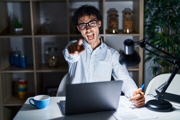 Poster - Hispanic man working at the office at night pointing displeased and frustrated to the camera, angry and furious with you