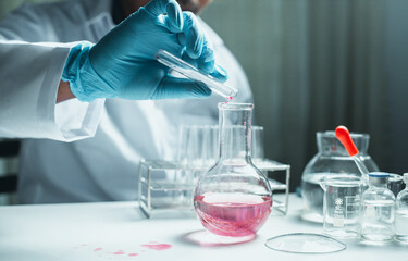 Scientist holding flask with lab glassware and chemistry laboratory test tubes Research and development in science laboratory, science technology concept
