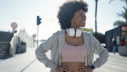 Poster - African american woman smiling confident wearing headphones at street