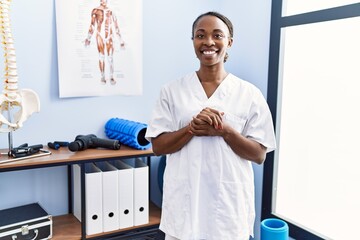 Poster - African american woman pysiotherapist smiling confident standing at rehab clinic