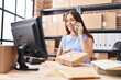 © Krakenimages.com - Young beautiful hispanic woman ecommerce business worker talking on smartphone holding package at office