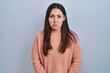 © Krakenimages.com - Young latin woman standing over blue background depressed and worry for distress, crying angry and afraid. sad expression.