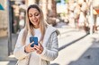 © Krakenimages.com - Young woman smiling confident using smartphone at street