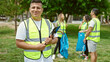 © Krakenimages.com - Group of people volunteers holding clipboard smiling confident at park