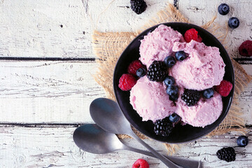 Wall Mural - Bowl of field berry ice cream. Above view table scene with copy space over a white wood background.