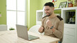© Krakenimages.com - Young arab man using laptop sitting on table dancing at home