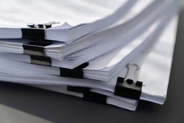 Closeup office table with organized stacked papers, as the concept of organized document management system for busy business reports or legal papers. equility