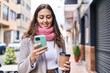 © Krakenimages.com - Young beautiful hispanic woman using smartphone drinking coffee at street