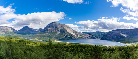 magical mountain massif that rises behind a pasture landscape in the blue cloudy sky at Morsvikbotn