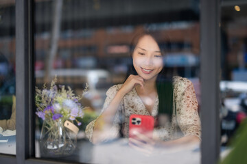 Canvas Print - Woman look at mobile phone and sit inside cafe