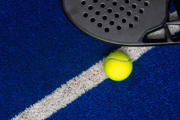 Wall Mural - Black professional paddle tennis racket and ball on blue background. Horizontal sport theme poster, greeting cards, headers, website and app