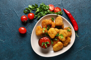 Wall Mural - Plate with delicious nuggets, ketchup and parsley on dark blue table