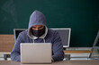 © Elnur - Young male hacker sitting in the classroom