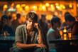 © wetzkaz - a sad young adult man is out and about, city or party or restaurant in the evening or at night, crowd of drunk people around and in the background. Generative AI