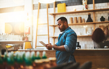 Focus, tablet and manager with man in cafe for online, entrepreneurship and startup. Retail, technology and food industry with small business owner in restaurant for barista, store and coffee shop