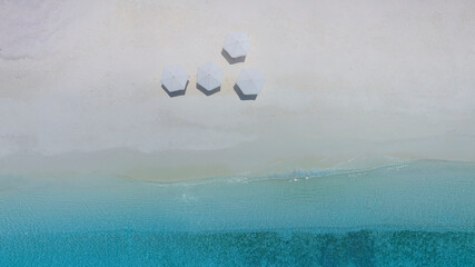 Top view of white umbrella on the beach with summer tropical and blue sky background