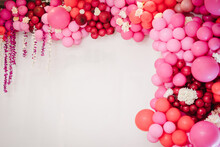 Arch With Balloons, Flowers For Party. White Photo Wall Decoration Space Or Place With Pink, Red, Maroon, Burgundy Balloons. Trendy Spring Decor. Celebration Concept. Birthday Party. Wedding Reception