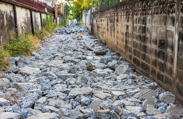 Wall Mural - A background view of a smashed concrete road lined with rubble.