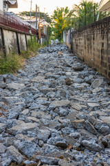 Wall Mural - A background view of a smashed concrete road lined with rubble.