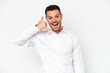 © luismolinero - Young caucasian handsome man isolated on white background making phone gesture. Call me back sign