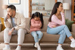 Upset Japanese Family Sitting With Bowed Heads After Conflict Indoor
