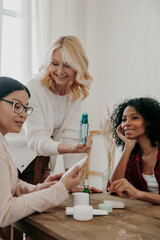 Wall Mural - Confident mature woman advising beauty products to friends while spending time together