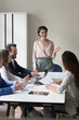 © fizkes - Business lady or coach lead group meeting or training in conference room. Clients take part in negotiations provide by mature company boss joking, provide information solve business laugh during break
