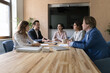 Businessman lead formal meeting with clients in conference room, make speech provide information take part in group briefing with colleagues gathered modern in boardroom. Negotiations, deal discussion