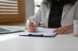 © saltdium - Close up and cropped image of Senior Mature Business woman doing financial report on her office desk