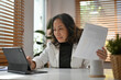 © saltdium - Senior Business woman working with digital tablet and financial document at the office desk.