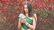 © Maksim - Yong Woman ilooking at screen of mobile phone. Green beautiful dress