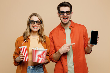 Poster - Young couple two friend family man woman wear 3d glasses casual clothes watch movie film hold mobile cell phone bucket of popcorn cup of soda pop in cinema isolated on plain beige background studio