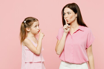 Wall Mural - Happy woman wear casual clothes with child kid girl 6-7 years old. Mother daughter say hush be quiet, finger on lips shhh gesture isolated on plain pastel pink background. Family parent day concept.