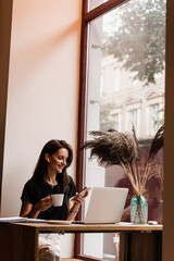 Confident business woman is chatting using laptop with colleagues via video connection and discussing new ideas. Happy girl with laptop is chatting with her friends and family in cafe.