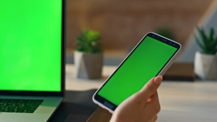 Wall Mural - Hand touching green screen mobile touchscreen answering call at office close up.