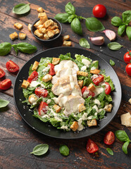 Wall Mural - A delicious chicken caesar salad with parmesan cheese, tomatoes, croutons and dressing