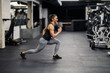 © dusanpetkovic1 - A sportswoman is doing lunges in a gym.