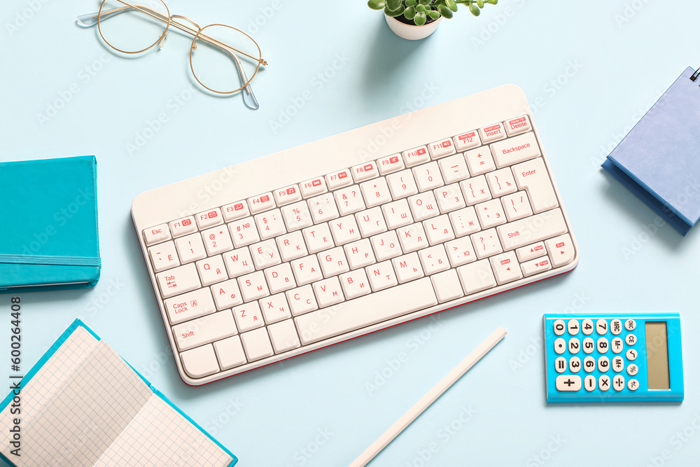 Composition with keyboard, glasses, notebooks and calculator on blue background