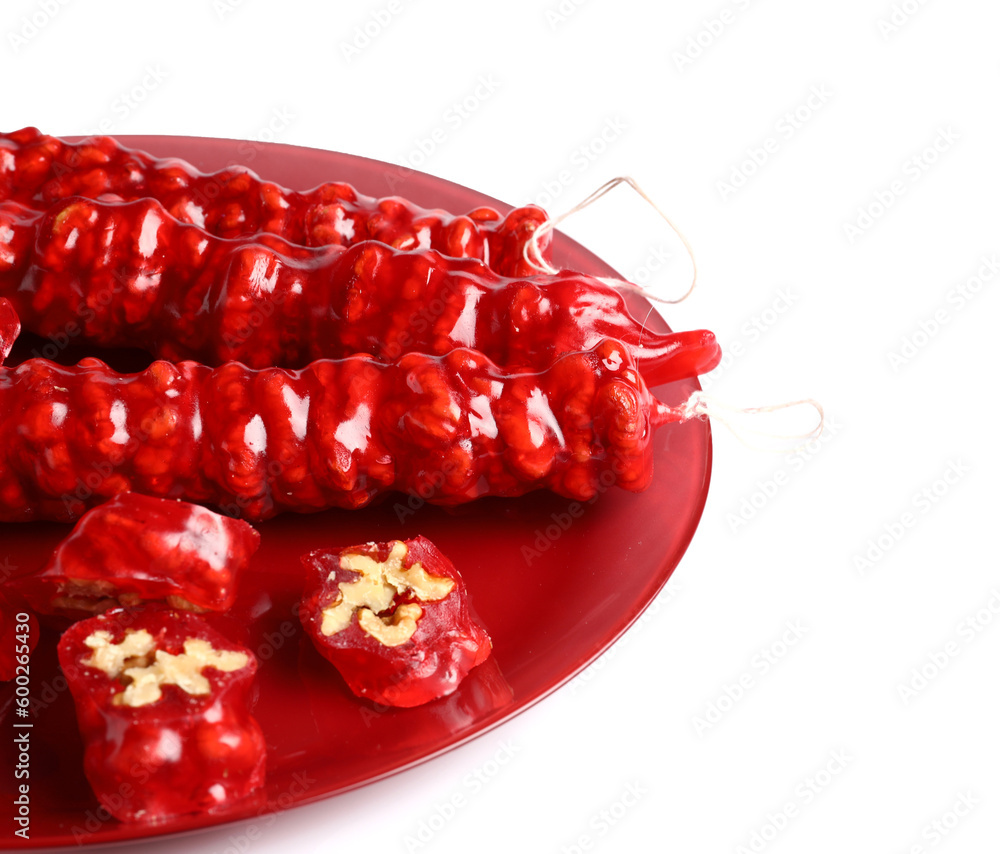 Plate with tasty churchkhela on white background, closeup
