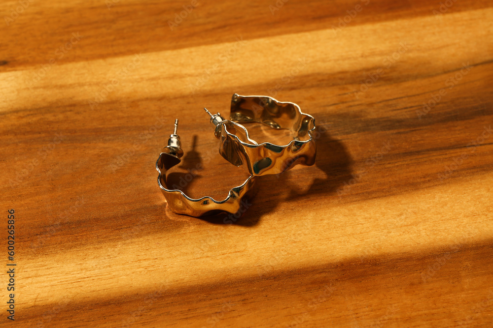 Beautiful earrings on wooden background