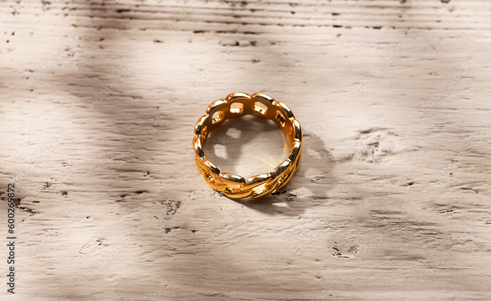 Beautiful ring on white wooden background