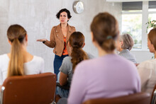 Positive Friendly Young Hispanic Female Tutor Giving Lecture To Group Of Women As Part Of Educational Program..